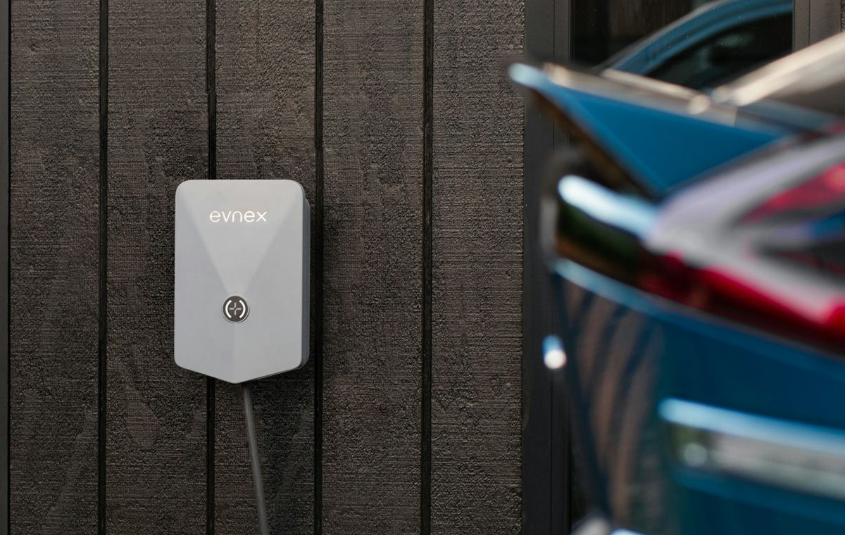 Wall-mounted home EV charger beside an electric car