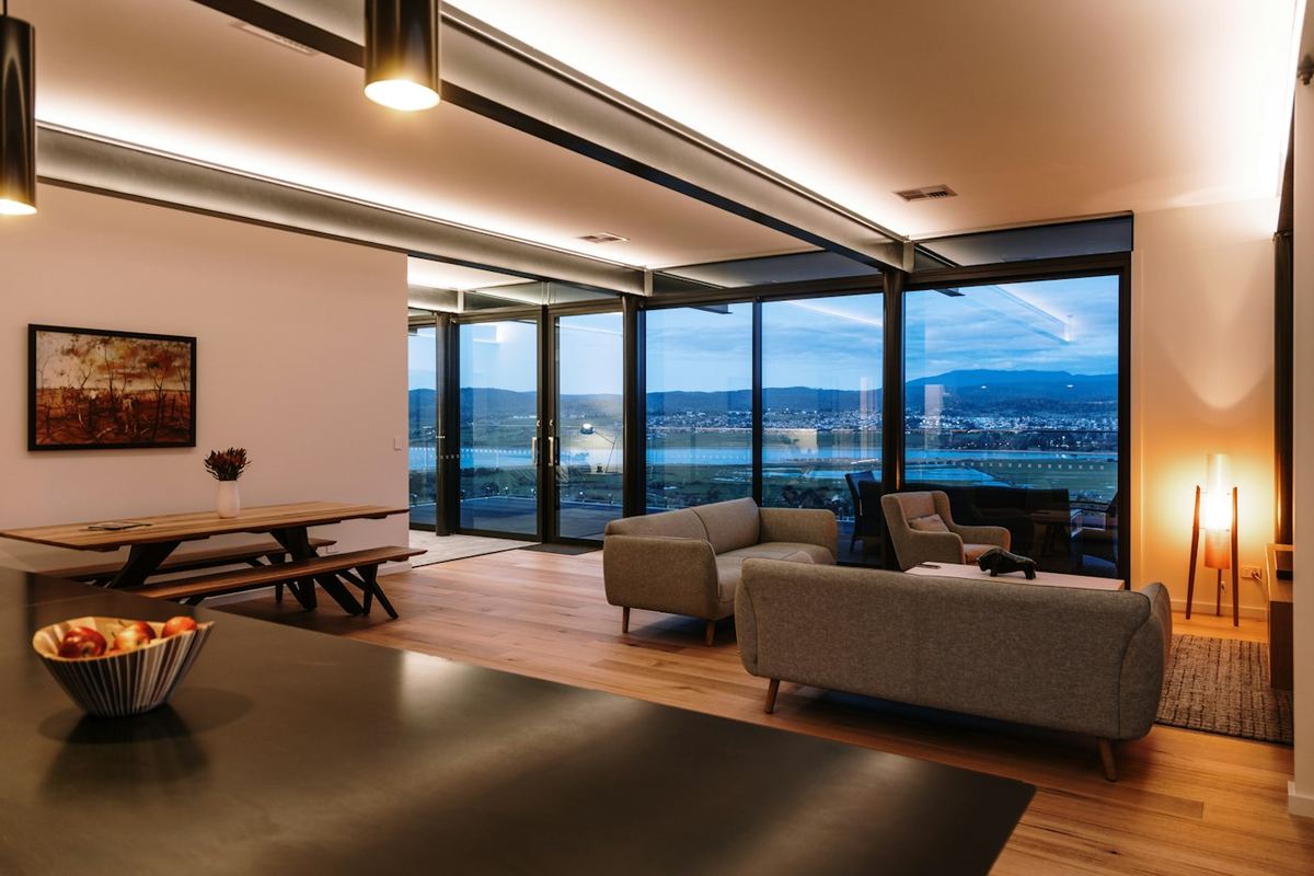 Modern living room lit with warm LED strip and downlights