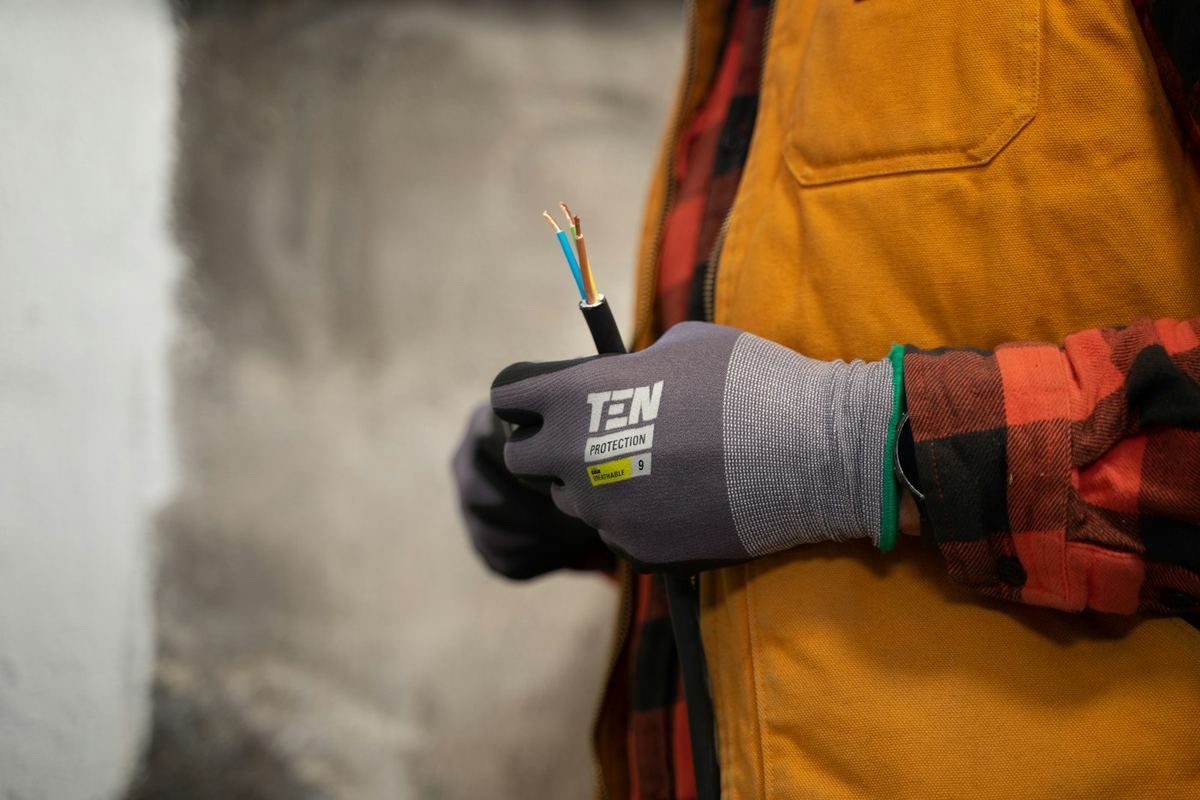 Electrician holding stripped electrical cable ready for wiring